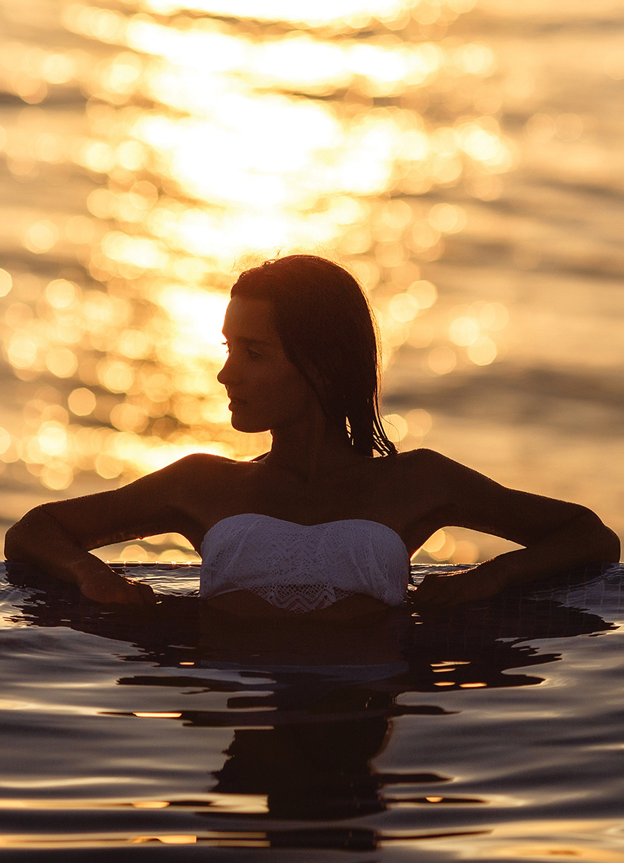 A woman relaxing in the sea at sunset